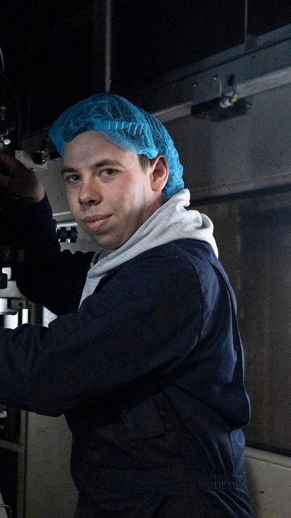A young apprentice student working on an industrial machine whilst on placement.