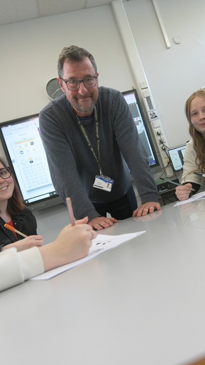 A group of students with their tutor at the centre, smiling at the camera.