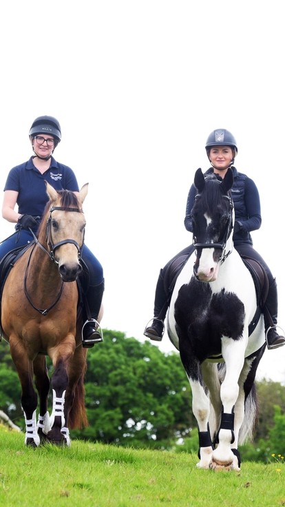 Two students riding horses.