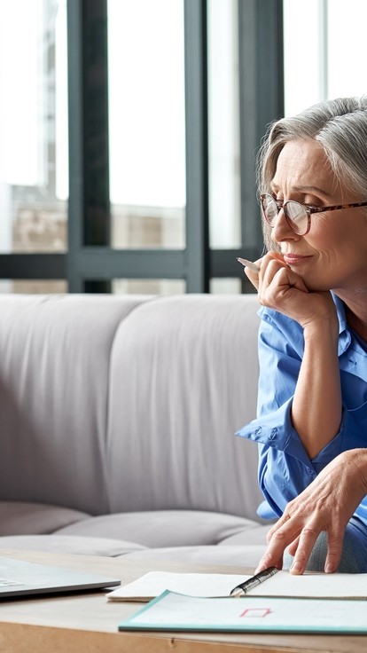 Woman with grey hair and a blue shirt completing a Learn Digital Direct course from the comfort of her home