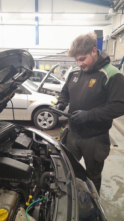 Brandon looking over a car engine