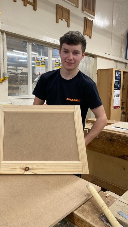 Guto working with some wood in the workplace