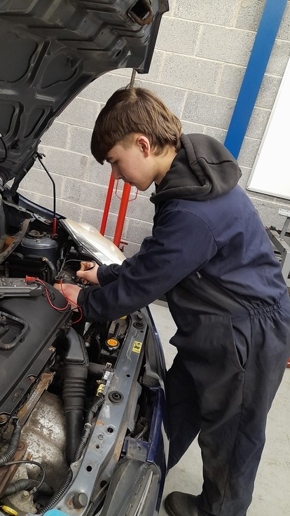 Looking under a hood of a car in workshop clothing