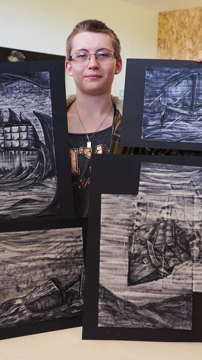 Nicole standing holding her work