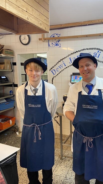 Charles and a member of the butchery team dressed in aprons and hats