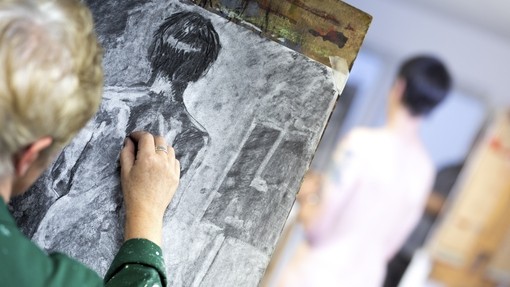 Over the shoulder shot of a student doing a charcoal sketch.