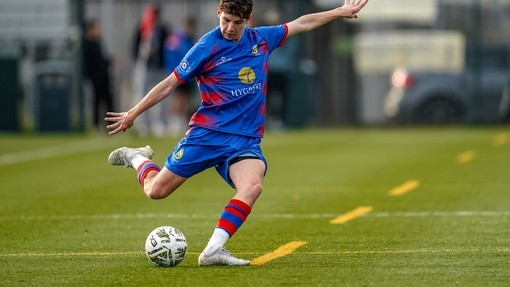 Student in blue uniform playing football.