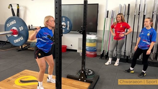A student lifting weights in the gym.
