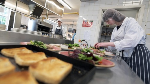 A student plates up a bread course.