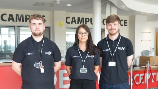 Three council employees standing by the college reception