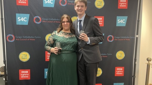 two students in front of backdrop