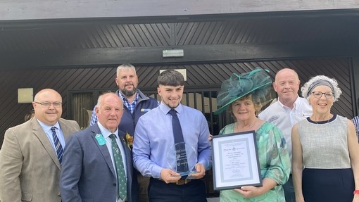 Rhys jones yn dal gwobr gyda grwp