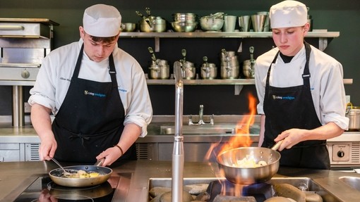 Two students flambeying at the training restaurant