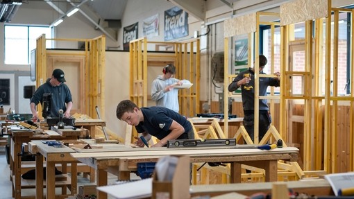 a group of students practicing site carpentry in a workshop
