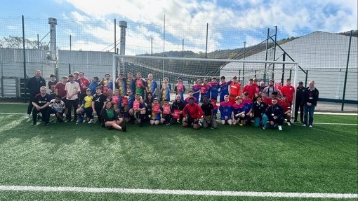 Students gather on a soccer field, showcasing teamwork and excitement during their football tournament.