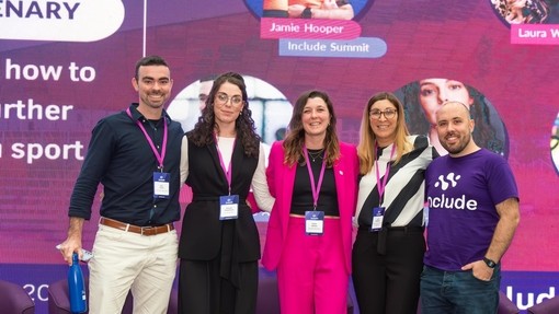 Georgia and three other speakers on stage with a bold purple background, creating an energetic atmosphere for their presentation
