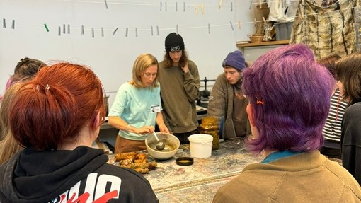 A team of people standing around a table, actively participating in a discussion and exchanging thoughts