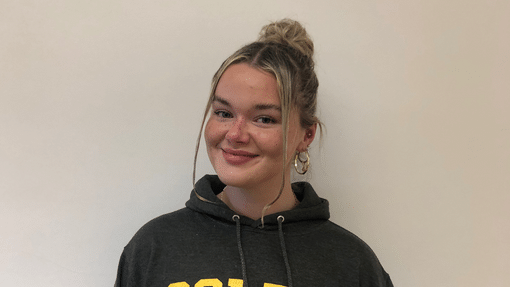 A student with a Coleg Cymraeg hoodie on in yellow and grey