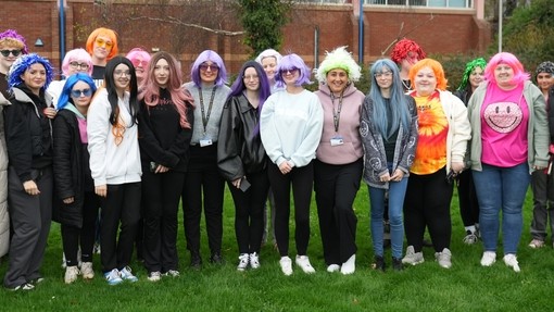 learners stood in a group wearing colourful wigs for a charity walk