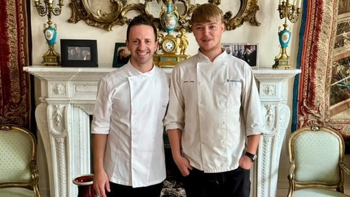 Oliver standing with the Italian chef in a very plush room