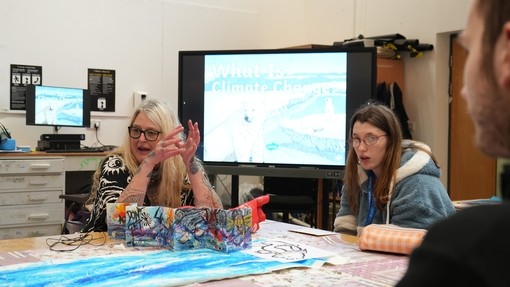 Dee Matthews talking to students around a table