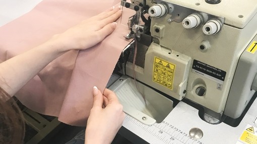 A student using a machine to construct a garment