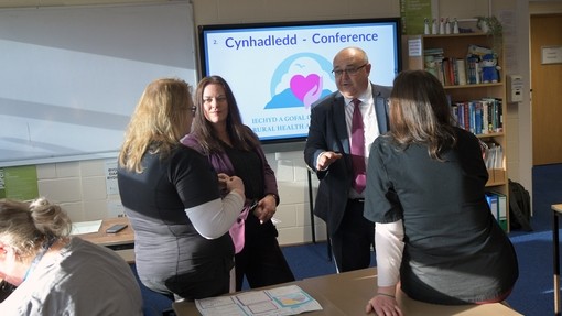The minister being shown a presentation in a classroom