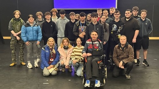 Paul with a group of students behind him in the college theatre