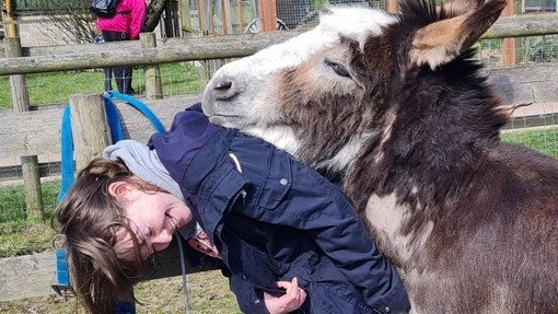 Laura bending with a head of a donkey coming in close