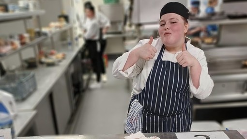 Libby giving a thumbs up at her cooking station