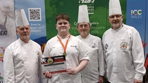 Ryan with his certificate and medal standing with three chefs