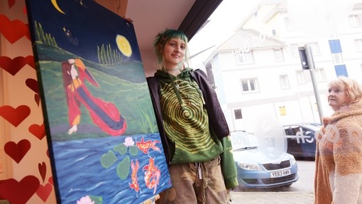 Student outside a shop window in Aberystwyth town