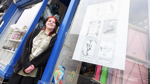 Student outside a shop window in Aberystwyth town