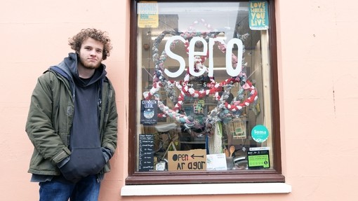 Student outside a shop window in Aberystwyth town