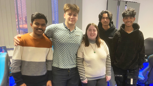 A group of students in a line in the esports room looking at the camera