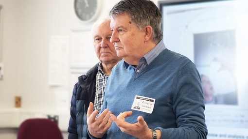 Two representatives from the photo society talking to students in a class