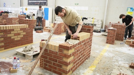 A student working in the competition with spirit level and bricks