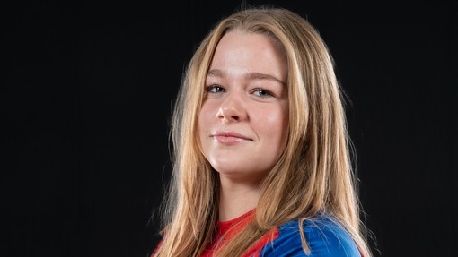Abigail Richards looking at the camera with folded arms in kit