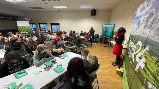 Classroom full of students during a green24 workshop, surrounded by green24 branding