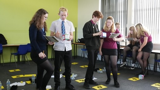Pupils standing in a classroom working out a task