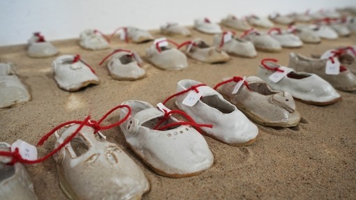 A close up of children's shoes made of clay, there are many