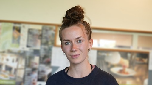 Amy head shot she's wearing a dark top and hair in a bun