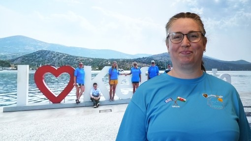 Grace in a blue top with I love Kefalonia behind her