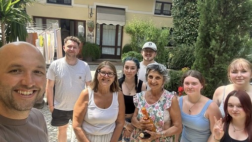 A group of students and lecturers in an Italian setting scenery looking at the camera