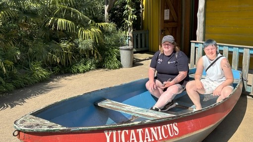 Two students in a mock boat outside an attraction