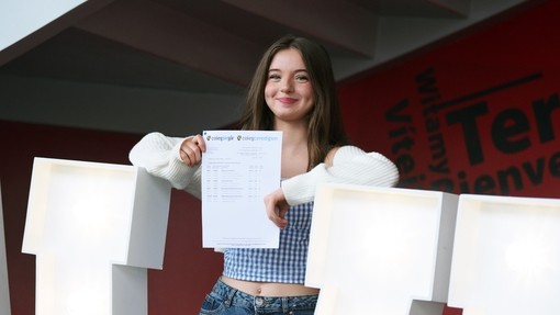 Erin standing in between large lit up letters spelling Da Iawn, with her results