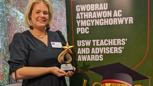 A member of staff holding an award