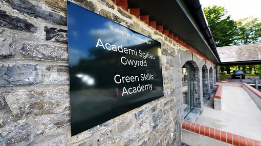 the outside of the arches building, a grey stone building with a green sign that says Green Skills Academy.