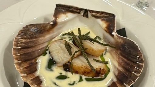 A scallop shell with cooked food inside it 