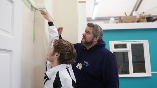 A Valspar Trade rep guiding a student with his painting